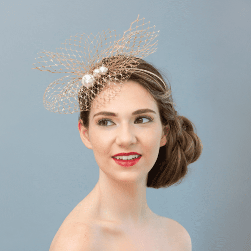 model wearing gold fascinator headband